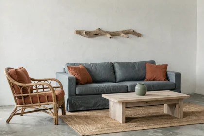 Salon bord de mer contemporain avec canapé bleu ardoise, coussins terracotta et sol en béton brut
